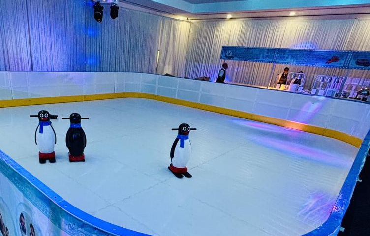 Synthetic ice rink set up indoors with penguin skating aids